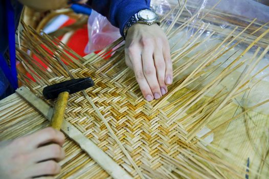 Boy doing traditional crafting work of basketry