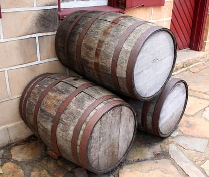 Old wooden barrels on the sidewalk.