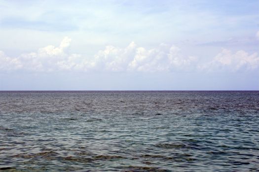 An ocean view from a cruise ship.  The sky is nice and cloudy.