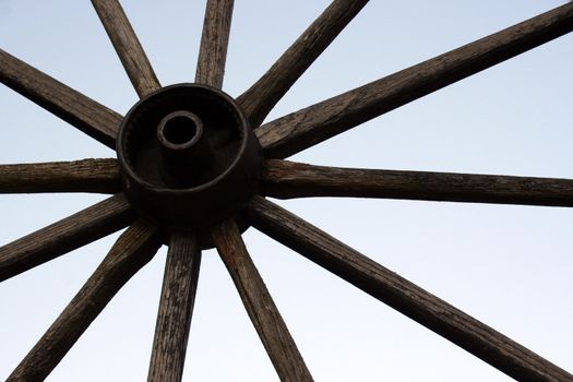 an old wagon wheel against the sky