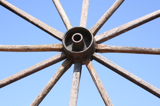 an old wagon wheel against the sky