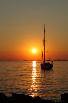 Gold romantic sunset with silhouette of yacht