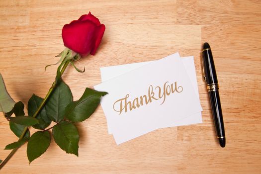 Thank You Card, Pen and Red Rose on a Wood Background.