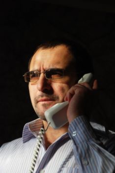 The businessman in a white shirt with stripes speaks by phone