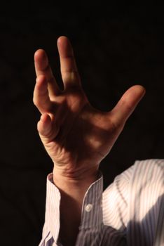 Strong man's hand with thumbs up. White shirt in stripes.