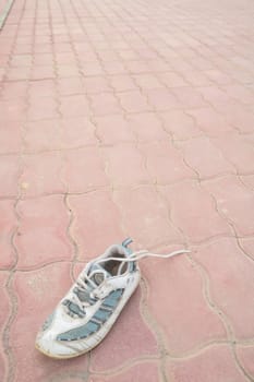 old thrown away sneakers on sidewalk