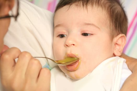 beautiful small child eats puree