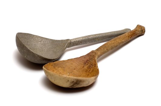 Wooden and antique pewter spoons on a white background.