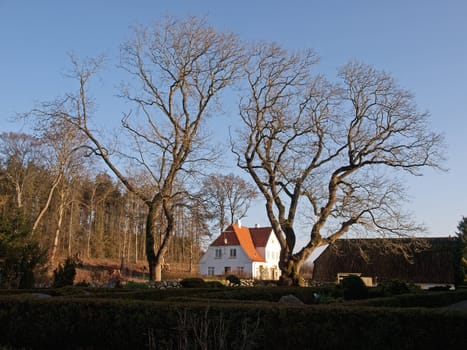 Traditional typical Danish country bricks home surrounded by trees Denmark