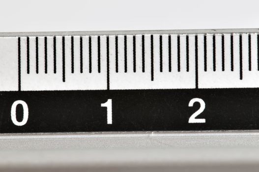 Metallic ruler in centimeters with white numbers and black markings