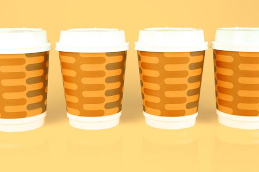 Takeaway coffee cups isolated against an orange background