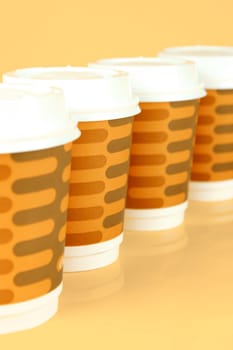 Takeaway coffee cups isolated against an orange background