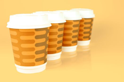 Takeaway coffee cups isolated against an orange background