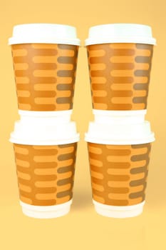 Takeaway coffee cups isolated against an orange background