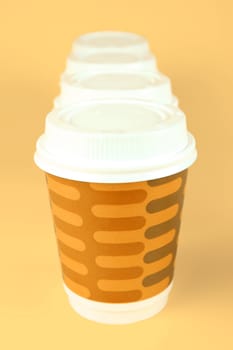 Takeaway coffee cups isolated against an orange background