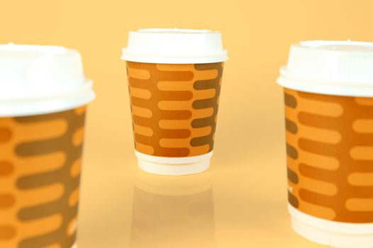 Takeaway coffee cups isolated against an orange background