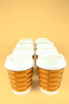 Takeaway coffee cups isolated against an orange background