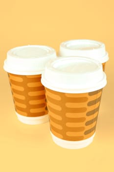Takeaway coffee cups isolated against an orange background