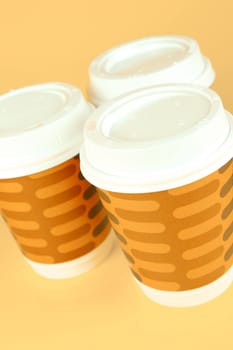Takeaway coffee cups isolated against an orange background