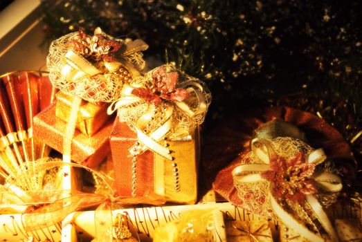 Two golden gift boxes with leaf of Mistletoe. Are tied up by tapes with bows
