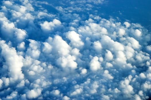 Aerial view from passanger's plane, many clouds covering sky somewhere above China.