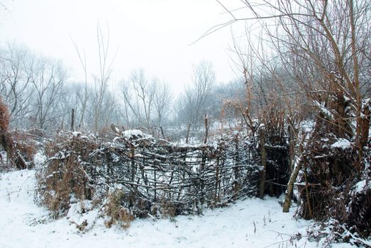 rural winter landscape with branch gate and boundary