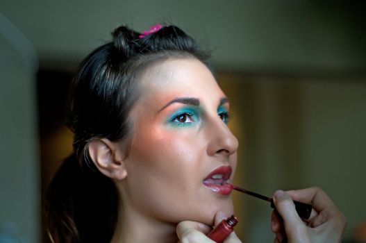 Shot of beautiful young woman applying makeup