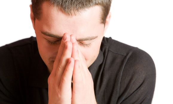 Young man praying with eyes closed closeup isolated on white