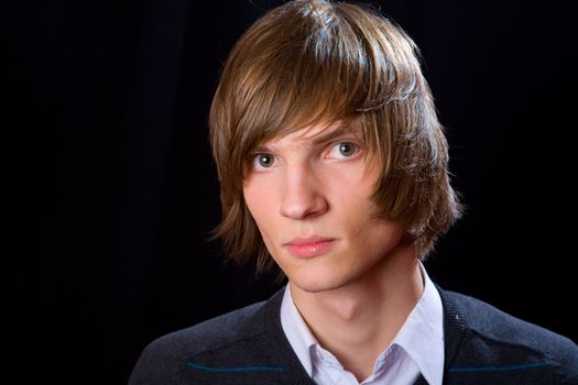 Portrait of Young serious man over black background