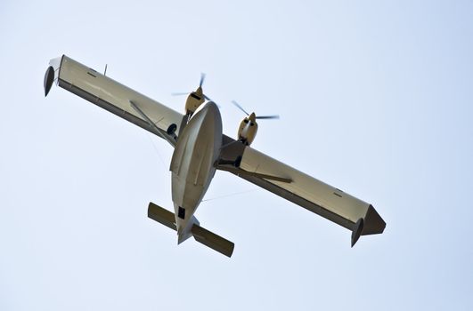 Hydro plane in the air. Against the background of blue sky. Photo was taken from the bottom. Close-up fuselage.