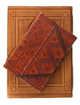 two diary books in red brown and red leather covers with rich stamped ornament isolated on white