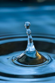 Bouncing water drops in blue background