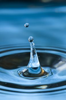 Bouncing water drops in blue background