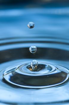 Bouncing water drops in blue background