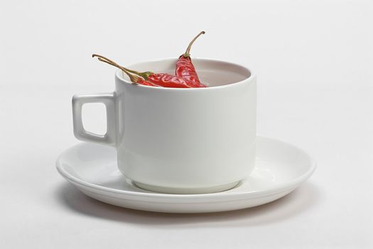 Macro shot of red hot chili peppers with white cup plate