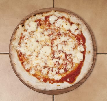 A margherita pizza on a wooden plate