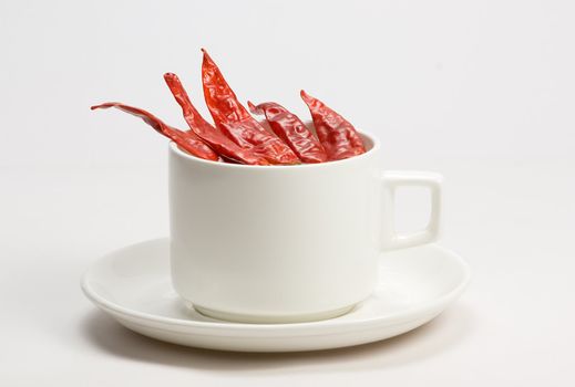 Macro shot of red hot chili peppers with white cup plate