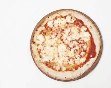 A margherita pizza on a wooden plate in white background