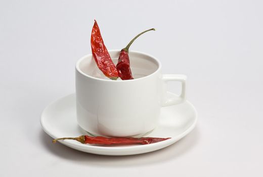 Macro shot of red hot chili peppers with white cup plate