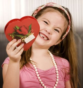 Cute little girl with a Valentine and funny expression