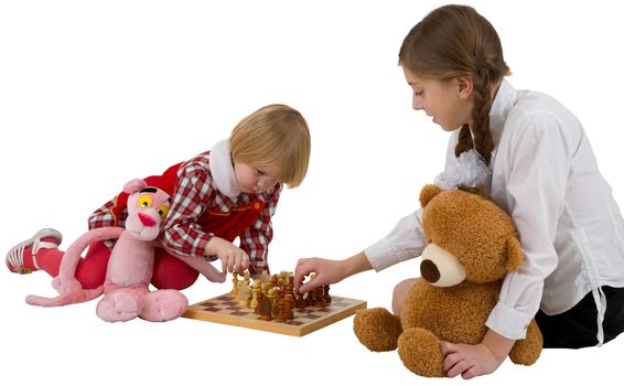 Girls play wooden classical chess on white