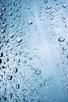 Raindrop in glass with dark blue sky background