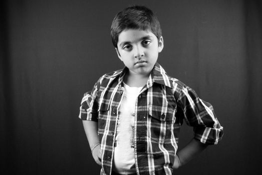 A black & white portrait of an angry Indian boy.