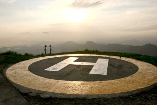 A peak helipad under sunset