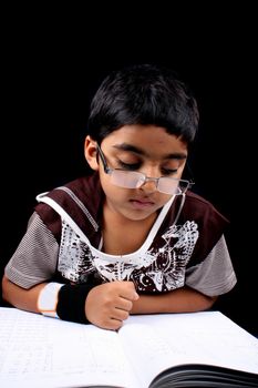 A studious Indian kid doing his homework.