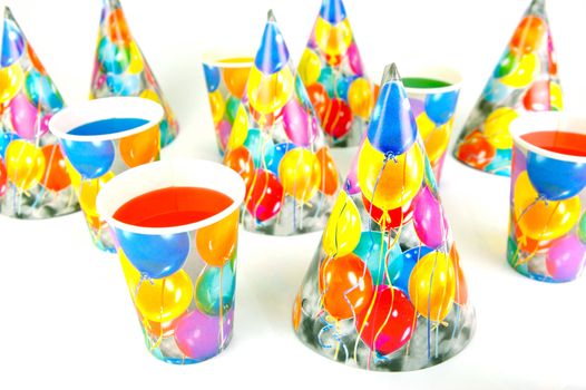 Party cups and hats isolated against a white background