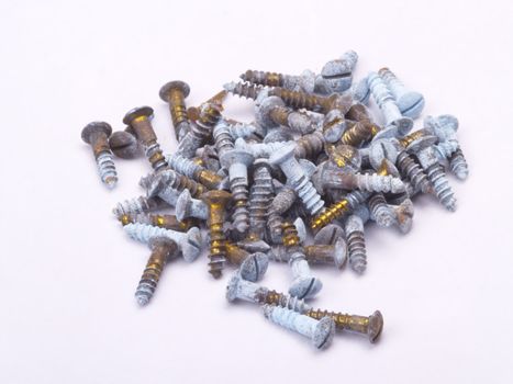 some old brass screws on off-white background