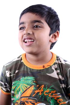 A portrait of a cute Indian kid laughing, on white studio background.