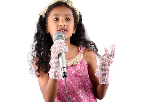 A talented little Indian girl singing, on white studio background.