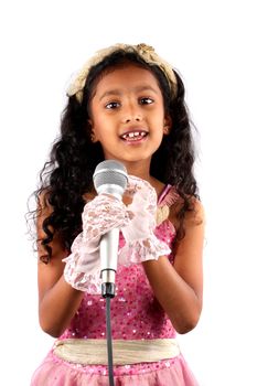 A young Indian girl in a performance, on white studio background.